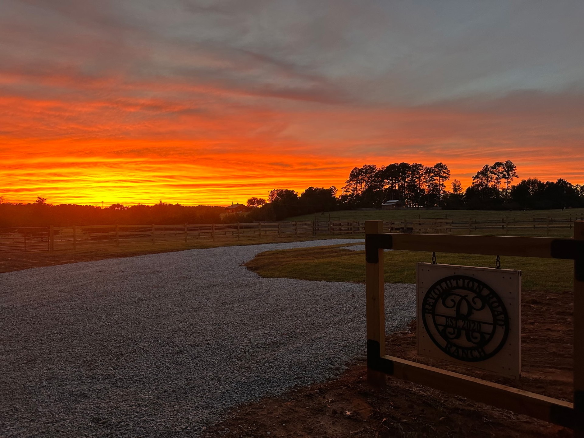A brilliant orange sunset over the entrance to Revolution Road Cattle Ranch